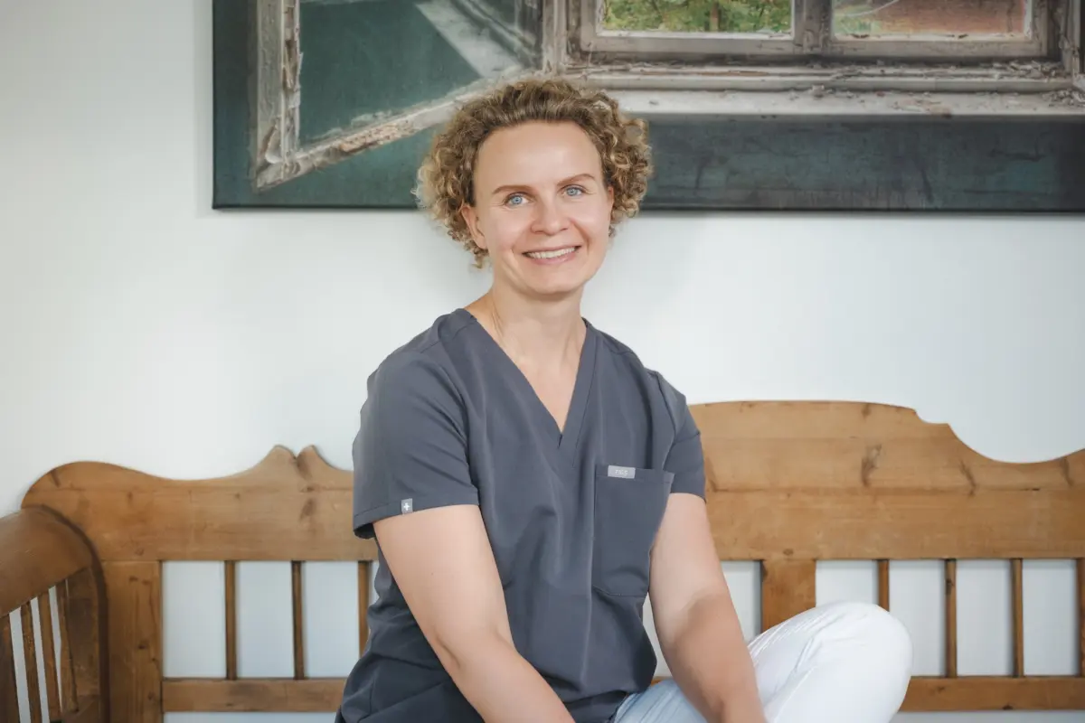 Dr. Natalia Kaschuba auf der Holzbank im Wartebereich der Praxis